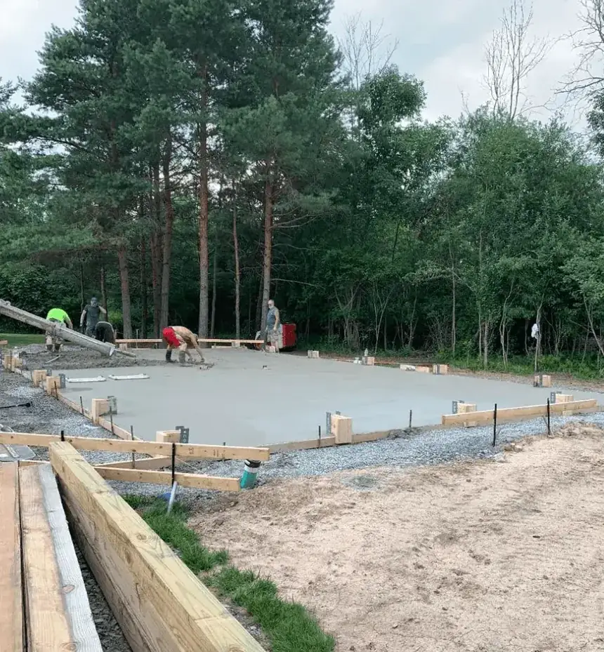 Liberty Pour Concrete crew finishing a formed concrete pad for a metal building in Clarence NY