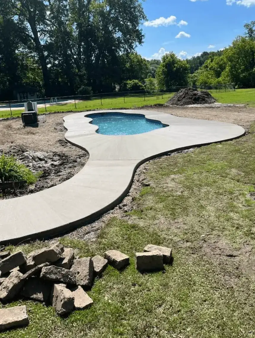 Curved concrete pool deck poured around a freeform pool in Elma NY by Liberty Pour Concrete
