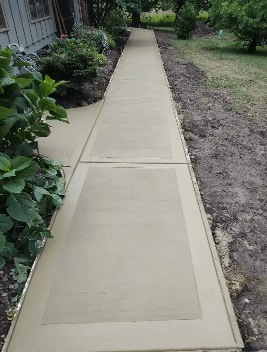 Long stained concrete sidewalk with tooled borders running beside a home — Liberty Pour Concrete