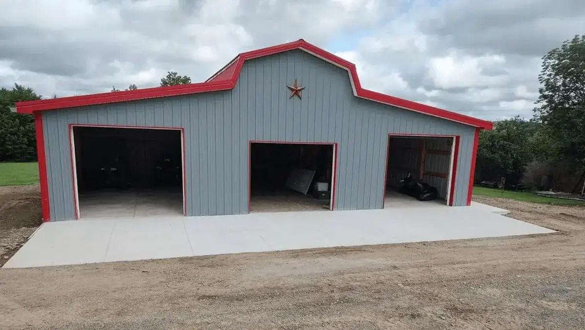 Concrete apron and floor pad poured for a three-bay pole barn with garage doors in East Elma NY by Liberty Pour Concrete
